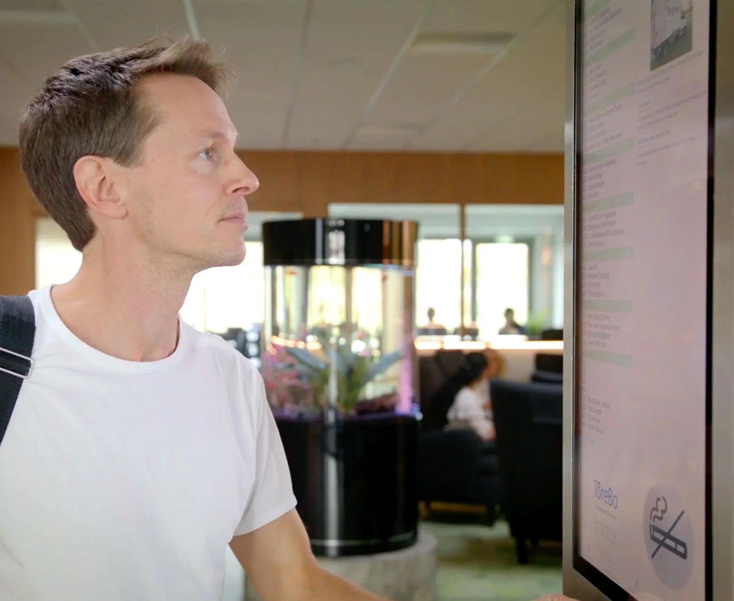 Boende l&auml;ser information p&aring; en digital entr&eacute;tavla