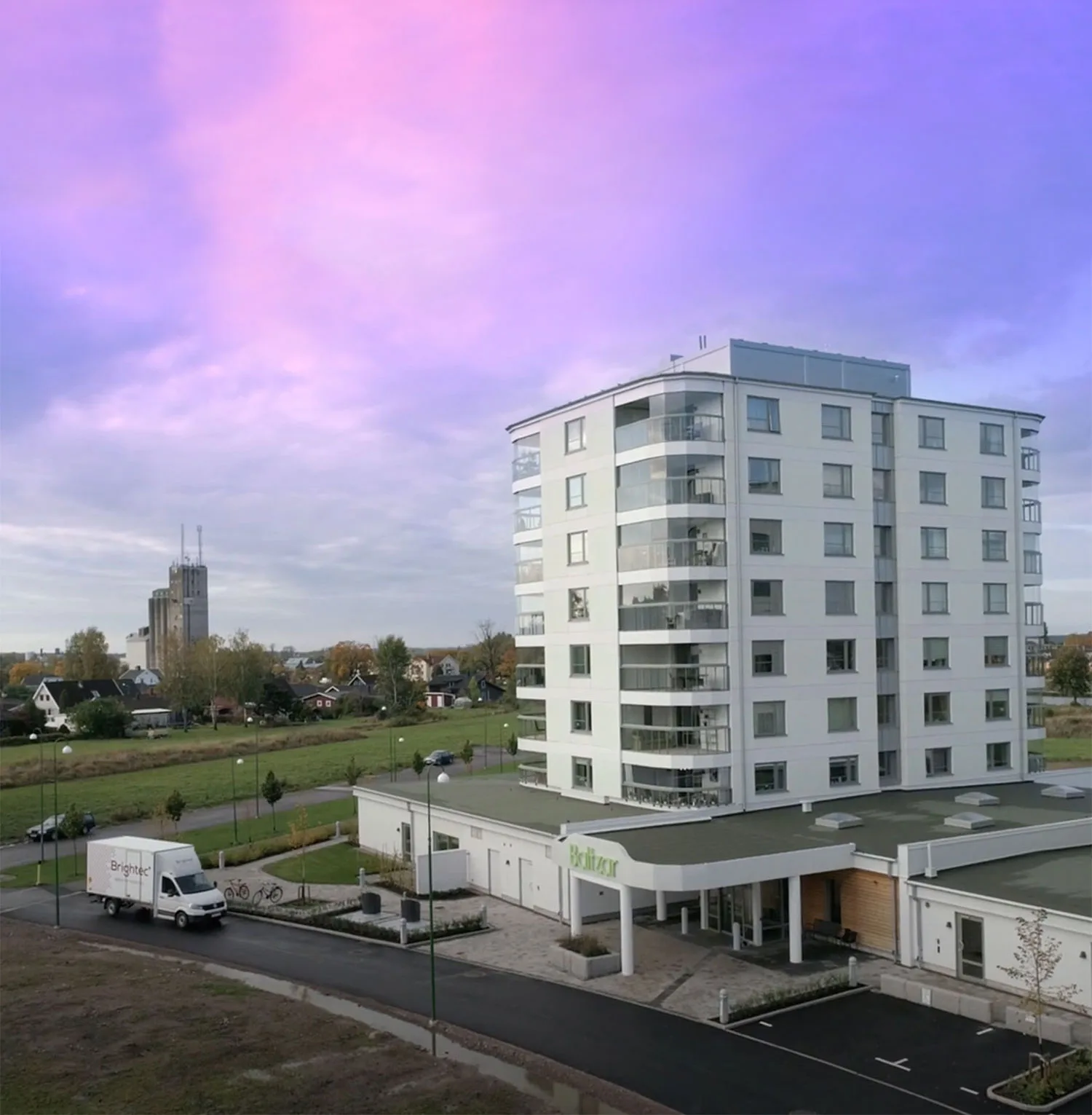 Flerbostadshus med en Brightec-bil parkerad utanför