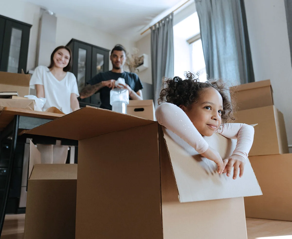 Familj som packar upp flyttkartonger i sin nya lägenhet