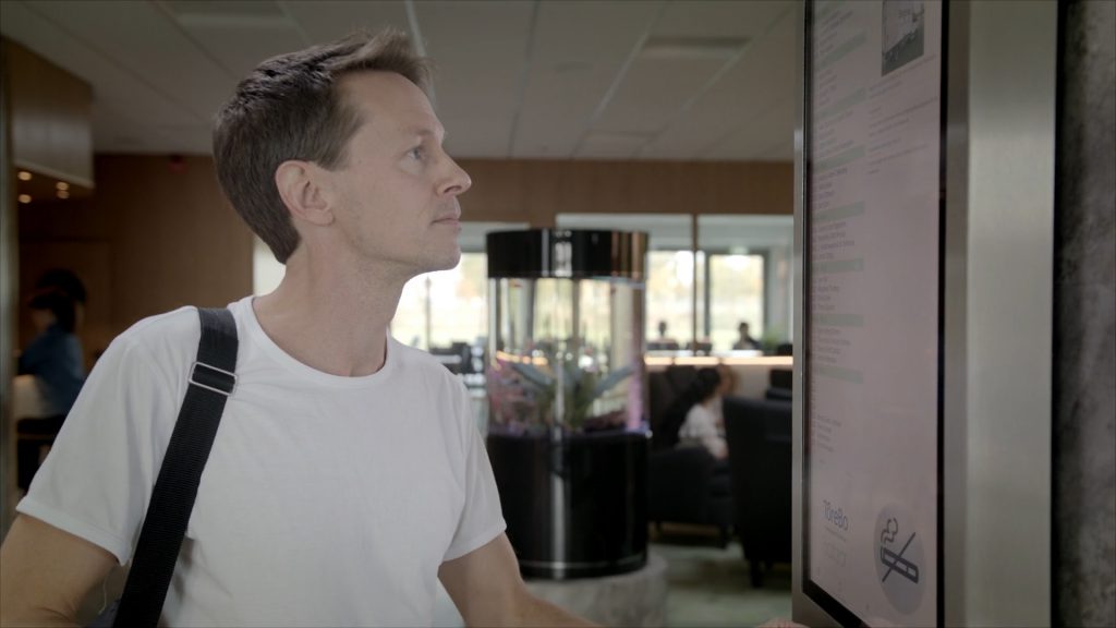 Man framför digital anslagstavla – Brightec Home